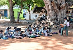 வகுப்பறை பற்றாக்குறையால் மரத்தடியில் படிக்கும் மாணவர்கள்