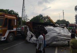 கழிவுகளுடன் கவிழ்ந்த கன்டெய்னர் லாரி; தேசிய நெடுஞ்சாலையில்  போக்குவரத்து பாதிப்பு