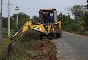  சாலையோர பள்ளத்தில் மண் கொட்டி சீரமைப்பு