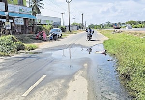 தேசிய நெடுஞ்சாலையில் தேங்கும் கழிவுநீரால் அவதி